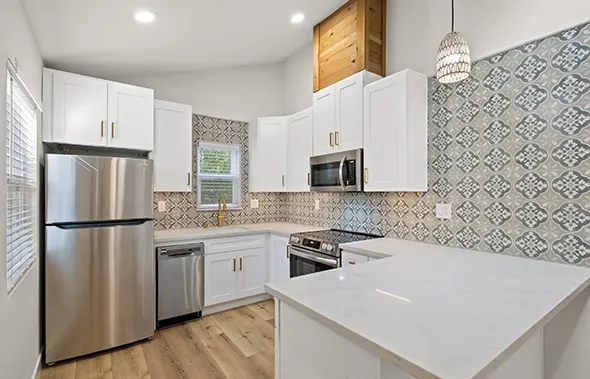 A kitchen with white cabinets and tile backsplash, showcasing Personalized ADU Planning design elements.
